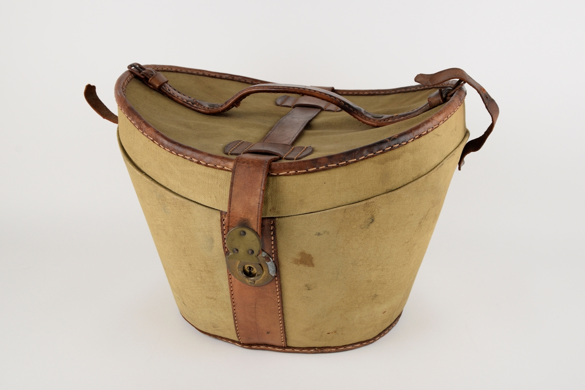 Hatteeske til flosshatt. 

Oval grunnflate. Sidene på esken skrår utover. Buet lokk. Reimer og kanter av skinn. Lokket er hengslet med skinnreim. Reimen går over lokket og ender i lås i front. Bærehåndtak av skinn på lokket, der endene har metallhemper for festing av reimer fra eskekroppen. Innvendig kledd med grå, mønstret tekstil. To reimer med trykknapp går på tvers av esken innvendig.