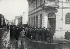 Lång kö utanför Växjö systembolag, 1917. Hörnet Klostergatan -  Norra Järnvägsgatan.