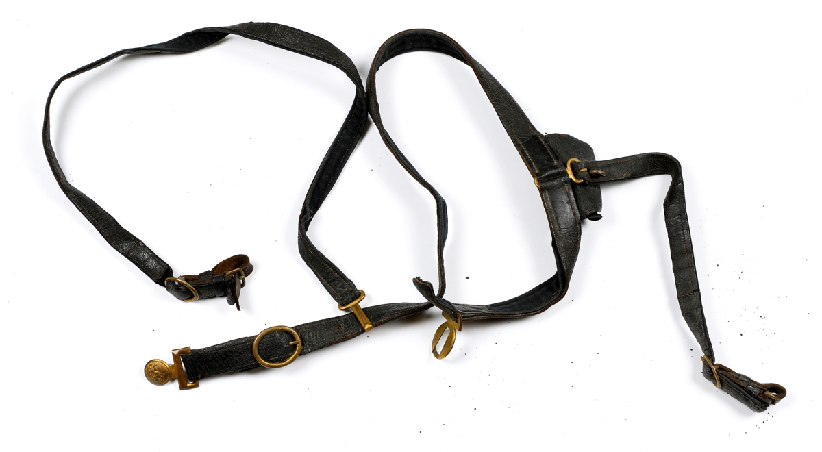 Norsk bandolær produsert mellom 1844 og 1905. Svartfarget lær med påsydd ullstoff på undersiden. Spenne i messing med løvefigur til å feste beltet foran. Bandolæret er montert feil vei og det kan mangle en kartusjveske.