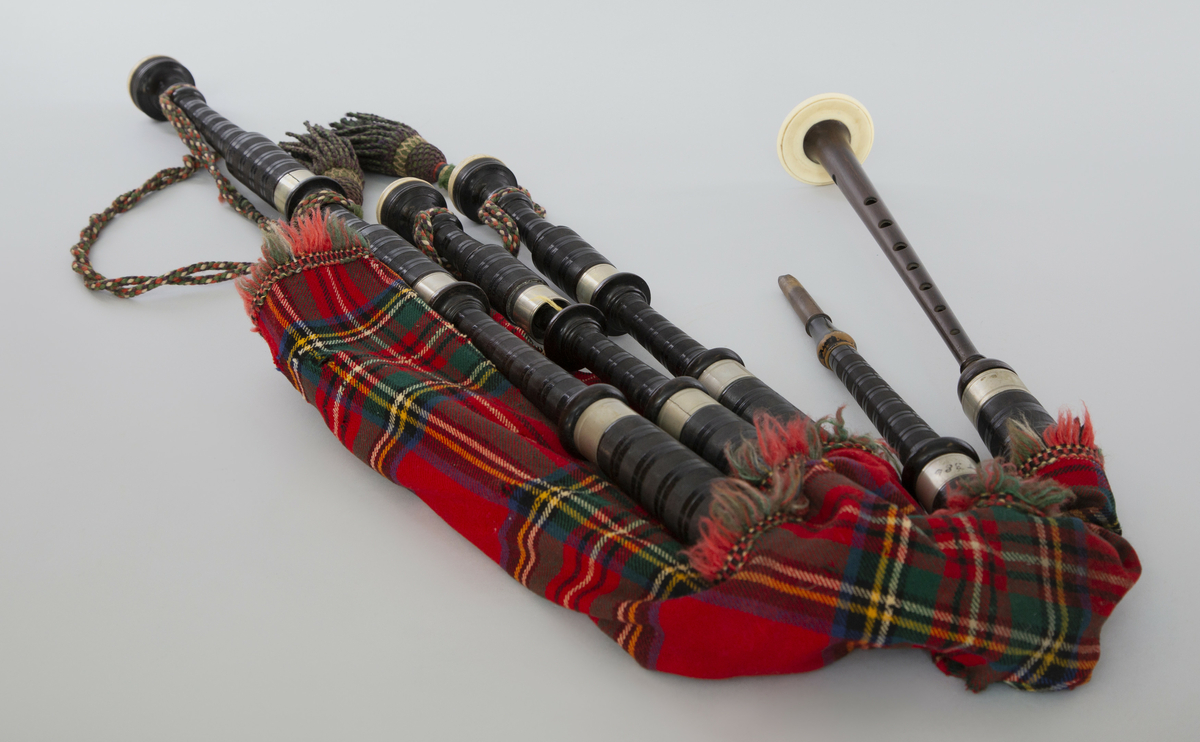 Instrument med vindsekken av skinn, trukket med skotskrutet stoff. Fire piper og ett innblåsningsrør. En skalmeie med syv hull foran og to på sidene. Skalmeien er totalt 45 cm lang og laget av mørkbrunt tre. En bordunpipe 45 cm, den andre 47,5 cm og den tredje 85 cm. Bordunpipene er i ibenholt, riflet på tvers, med sølvringer. Snor med dusk i hver ende er knytet slik at alle pipene er lenket sammen.