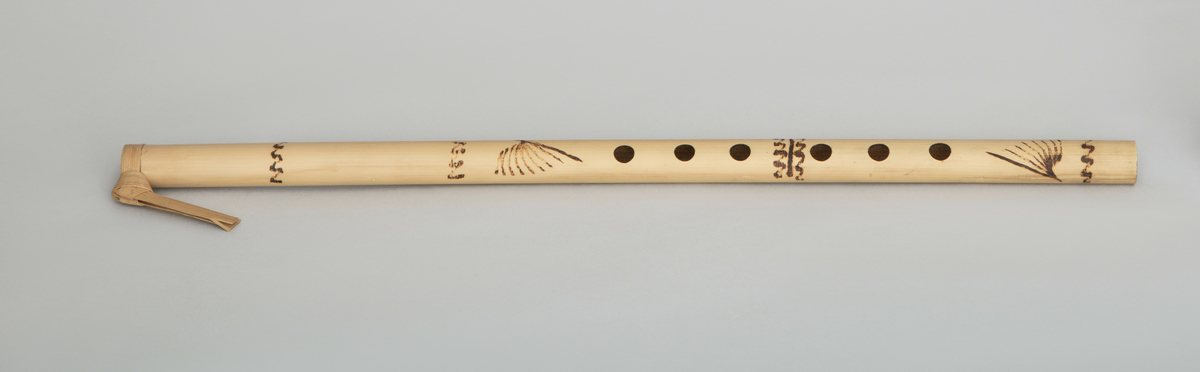 Spaltefløyte av bambus. Spalten dannes ved hjelp av en løs ring av tørket blad som festes rundt røret. Utvendig dekorert med enkel symmetrisk innbrent dekor.
6 fingerhull. Sylindrisk boring.

Instrumentet er p g a spalteringens utforming - palmeblad medknute og endene av bladet vendt nedover - karakteristisk for Vest-Javas så kalte Sunda-stil. (medd. fra tidl. eier.)