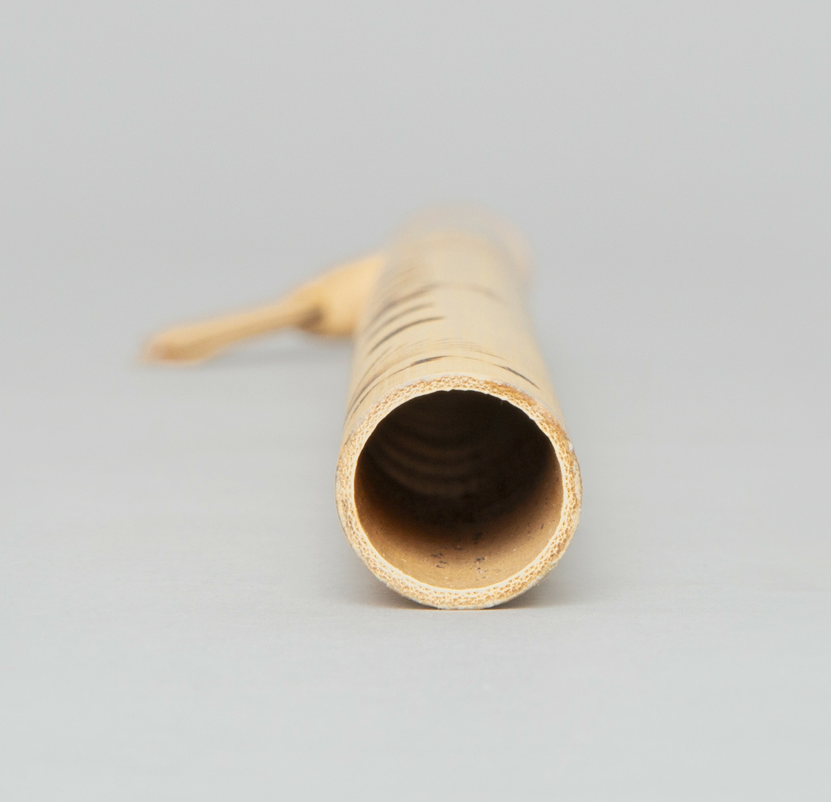 Spaltefløyte av bambus. Spalten dannes ved hjelp av en løs ring av tørket blad som festes rundt røret. Utvendig dekorert med enkel symmetrisk innbrent dekor.
6 fingerhull. Sylindrisk boring.

Instrumentet er p g a spalteringens utforming - palmeblad medknute og endene av bladet vendt nedover - karakteristisk for Vest-Javas så kalte Sunda-stil. (medd. fra tidl. eier.)