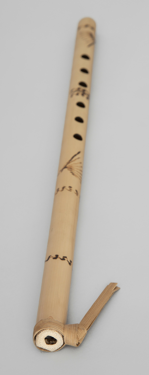 Spaltefløyte av bambus. Spalten dannes ved hjelp av en løs ring av tørket blad som festes rundt røret. Utvendig dekorert med enkel symmetrisk innbrent dekor.
6 fingerhull. Sylindrisk boring.

Instrumentet er p g a spalteringens utforming - palmeblad medknute og endene av bladet vendt nedover - karakteristisk for Vest-Javas så kalte Sunda-stil. (medd. fra tidl. eier.)