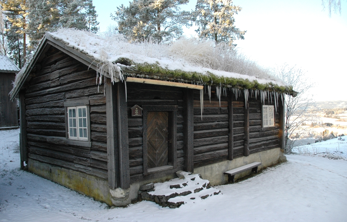 Dette huset er livørsbygning på Hadelandstunet. Det er ei laftet enetasjes stue
med torvtak som ble satt opp på museet i 1924. Bygningen har treromsplan med
gang og kove i tillegg til selve stua med peis. I koven er det trapp opp til et loft
som ble brukt som lagringsplass.
Huset stod opprinnelig på Vøyen i Gran, men var flyttet til Morstadhagen/Morstadbråten
før det kom til museet.
