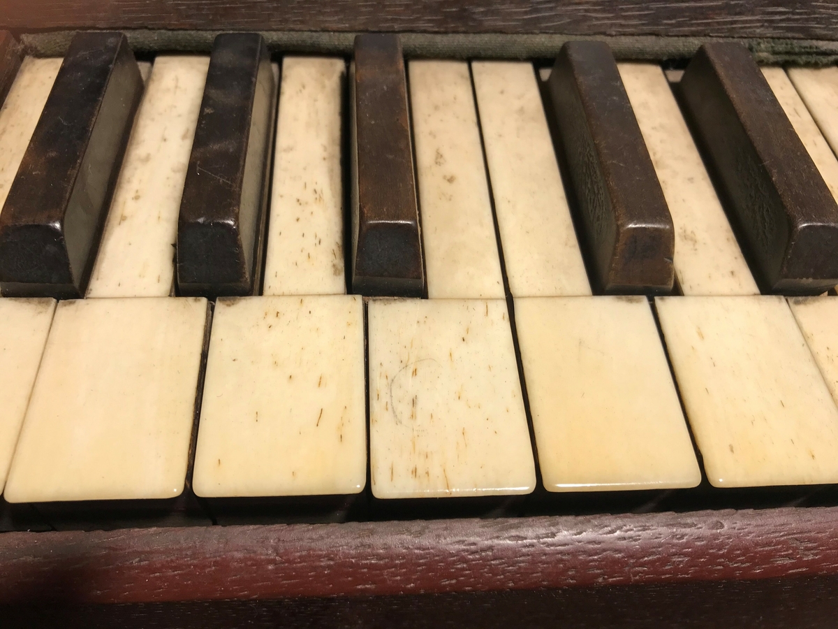 Trykkluft harmonium med 29 hvite tangenter. Tangentene er mulig laget av elfenbein.