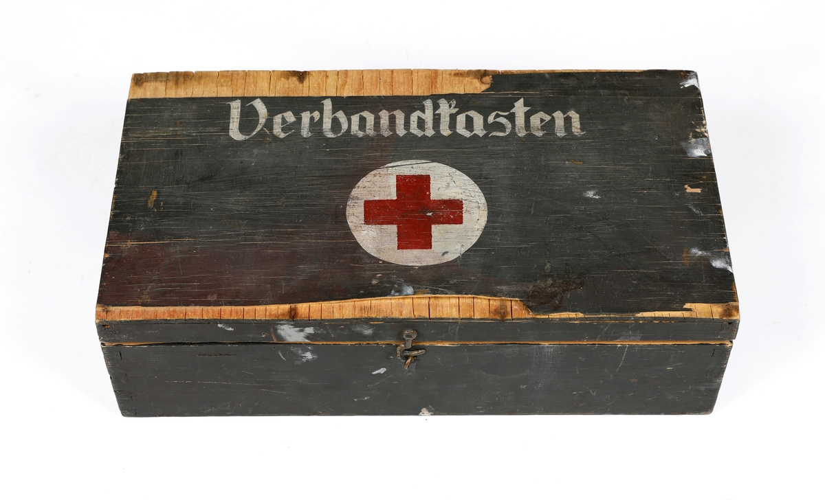 Tyskprodusert treskrin til sanitetsutstyr brukt i felt under andre verdenskrig. Skrinet kan lukkes med en metallhempe. På lokket er det skrevet Verbandtasten og malt på et rødt kors i en hvit sirkel. På innsiden er det ro rom og på lokket er det festet en papirlapp hvor det er skrevet:
Inhaltsverzeichnis des Kfz. -Kastens
1 Flasche Jodtinktur
5 Sicherheitsnadeln
4 kleine Verbandpekehen
6 grosse Verbandpekehen
1 Dreiecktuch
1 Abschntirbinde
2 Brandbinden
1 Presstück
1 Packet Polsterwatte
1 Drahtschiene
1 Rolle Leukoplast
1 Raiserklinge als Ersats für Kleiderschere
