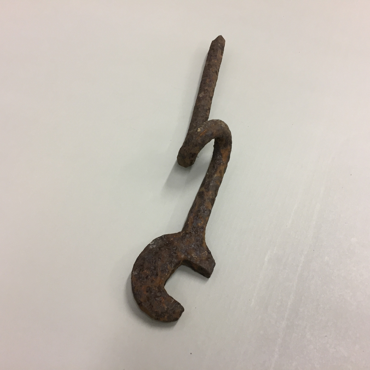 Reidskap i metall. Forma som ein skiftnøkkel i enden, med ein snurr på midten. Ukjent bruksområde