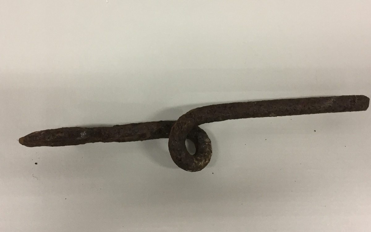 Reidskap i metall. Forma som ein skiftnøkkel i enden, med ein snurr på midten. Ukjent bruksområde