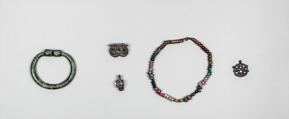 Gravfynd från hög nummer 22 i Strömsbro, Gästrikland. Båtgrav, kvinnograv, brandgrav.

Vikingatida hängsmycke i brons, föreställande två fåglar inplacerade i en cirkel. Troligtvis framställt enligt à cire perdue-metoden; modellen gjordes i vax som omgavs av en lermantel, varefter vaxet smältes ut och bronsen göts i tomrummet.