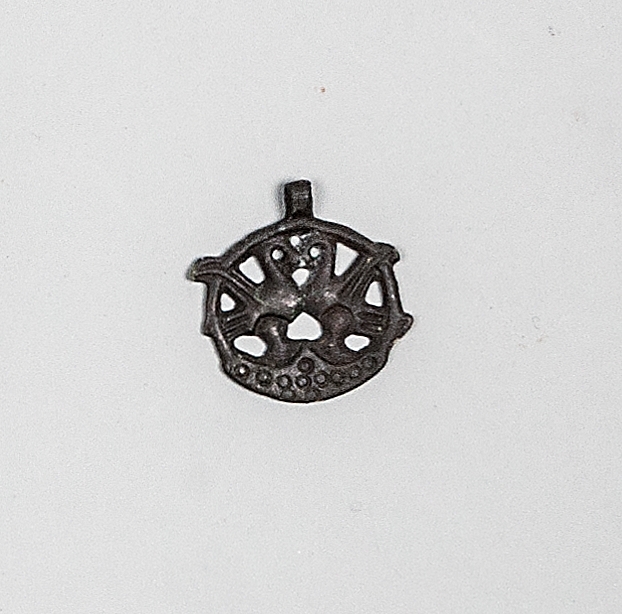 Gravfynd från hög nummer 22 i Strömsbro, Gästrikland. Båtgrav, kvinnograv, brandgrav.

Vikingatida hängsmycke i brons, föreställande två fåglar inplacerade i en cirkel. Troligtvis framställt enligt à cire perdue-metoden; modellen gjordes i vax som omgavs av en lermantel, varefter vaxet smältes ut och bronsen göts i tomrummet.