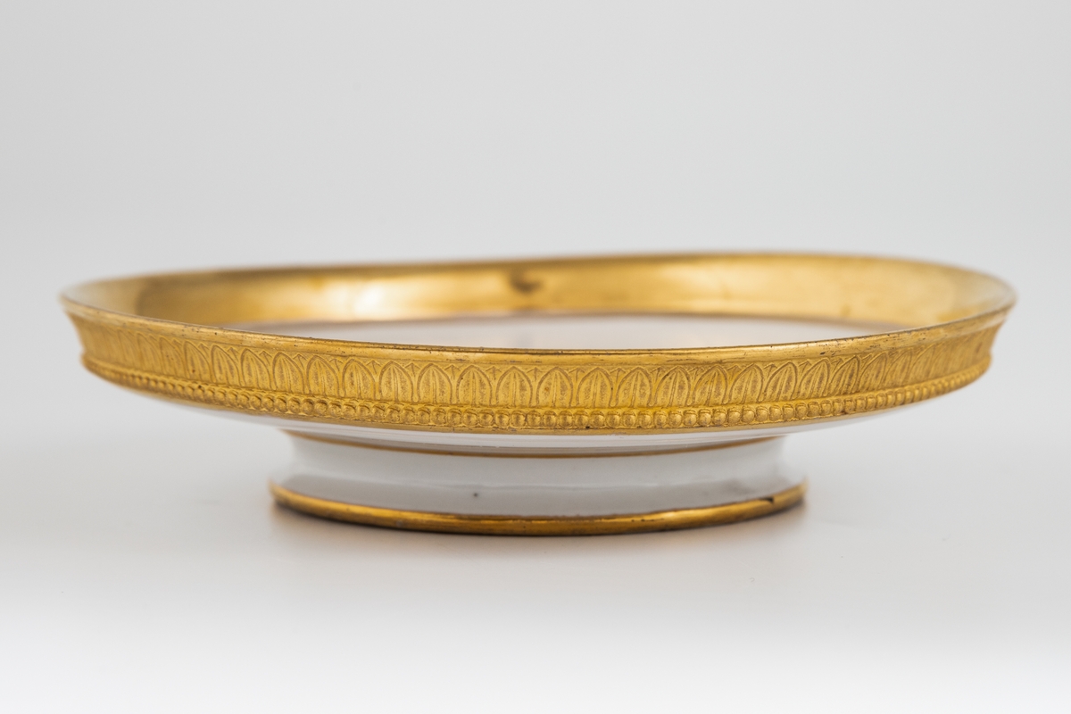 Koppen er dekorert med antikke ornamenter: Et bånd med ionisk kymation (eggstav) langs randen og nederst på koppens korpus. Rundt foten et bånd med lesbisk kymation. Håntak formet som et akantusblad. Et bånd med ionisk kymation på utsiden av skålen og tvunnet tau i speilet.