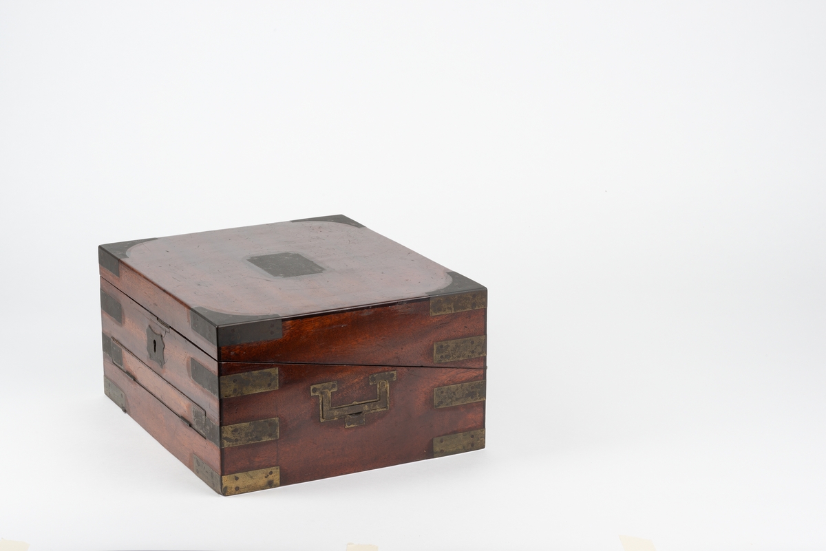 Rektangulær trekasse med kopieringsmaskin. Kassen har flere rom og skuffer. Inni lokket er det et rom som kan åpnes ved å løfte på en klaff. Dette rommet kan være til oppbevaring av papir. Klaffen er foret med filt på den ene siden. Nede i kassa er det en liten, løs trekasse som kan tas ut. I denne er det plass til to blekkhus og pennesplitter. Under den løse trekassen er det et rom med en valse i metall. Valsen kan dreies rundt med en løs sveiv. I bunnen har kassen en uttrekkbar skuff. Kassen har beslag og bærehåndtak i metall. Til kopieringsmaskinen følger det med en løs sveiv, et løst håndtak, et blekkhus og en liten kost.