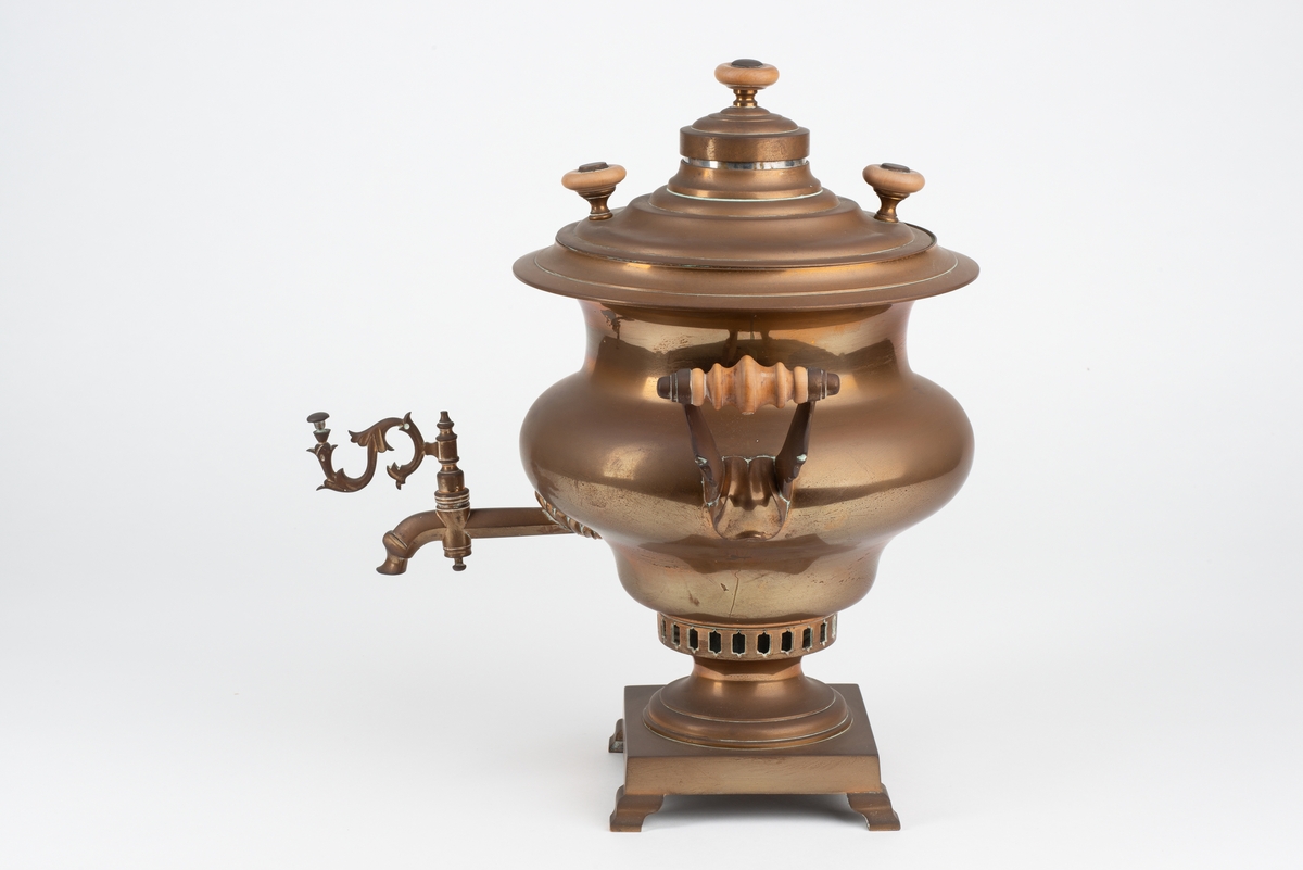 Tekoker i messing. Støpt i tre deler med to lokk. Håndtak av tre på sidene. Tre mindre håndtak og en ventil på øvre del. Dekorativ kran med lukkeventil.