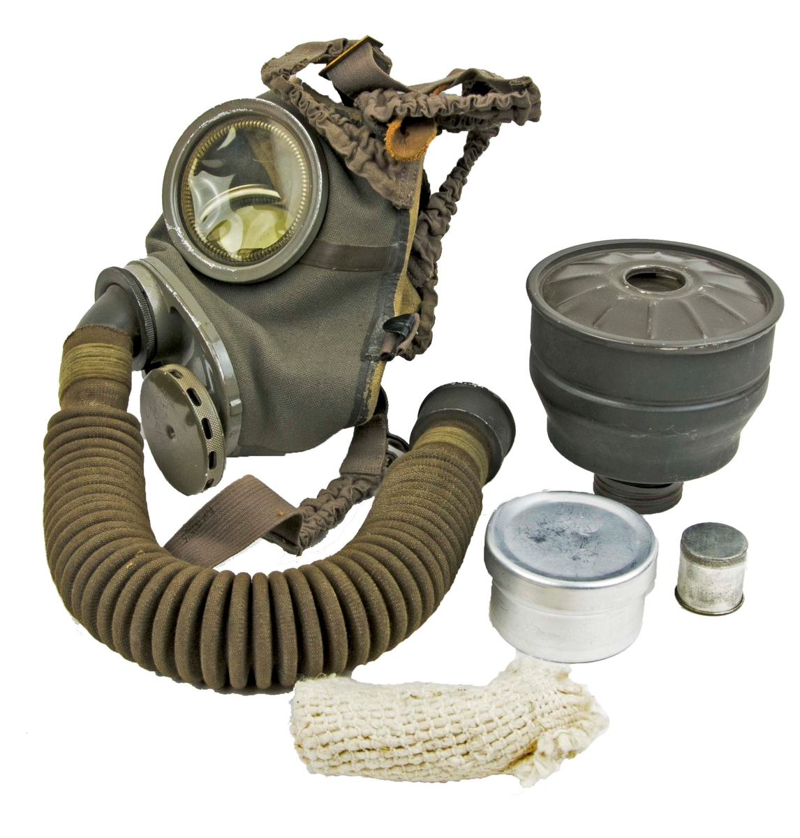 Skyddsmask modell 1931 - 1936. Förvaras i grön tygväska med axelremmar.
I väskan medföljer en stålburk med imskivor till gasmask, mindre stålburk med en tejprulle, en trasa, gasfilter, mask samt slang m/31.

Två blanketter medföljer i väskan, ett utdrag ur rekrytundervisning för Flygvapnet 1938 samt en Materielreversal.