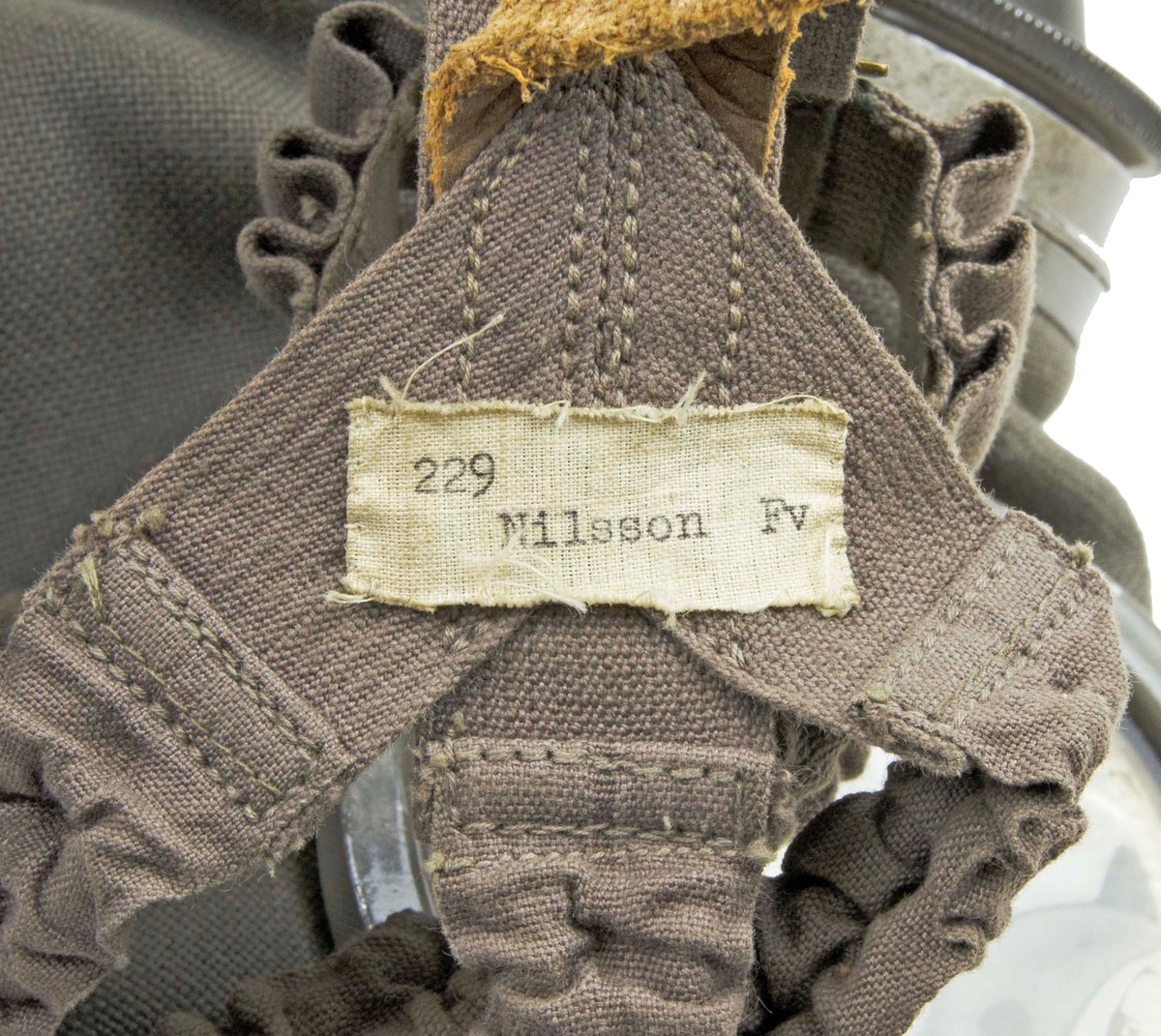 Skyddsmask modell 1931 - 1936. Förvaras i grön tygväska med axelremmar.
I väskan medföljer en stålburk med imskivor till gasmask, mindre stålburk med en tejprulle, en trasa, gasfilter, mask samt slang m/31.

Två blanketter medföljer i väskan, ett utdrag ur rekrytundervisning för Flygvapnet 1938 samt en Materielreversal.