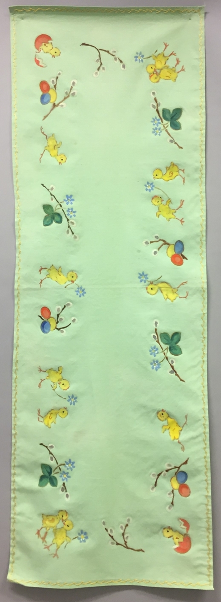 Løpar med trykt motiv. Kyllingar, blåveis og seljekvistar med "gåsungar". Handbrodert kant rundt alle sidene.