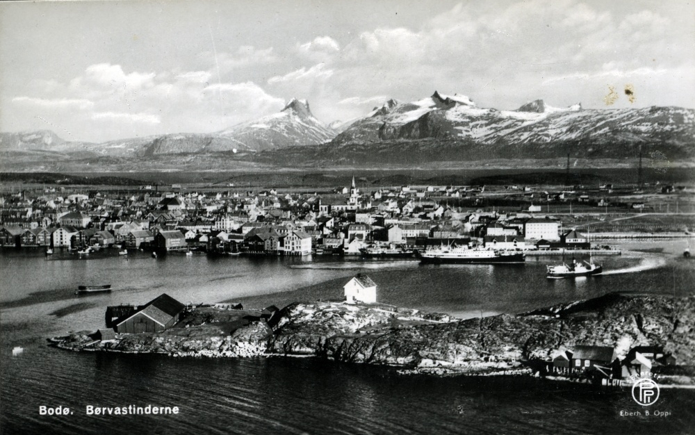 Postkort med flyfoto over Bodø sentrum med Børvasstindene i bakgrunnen.