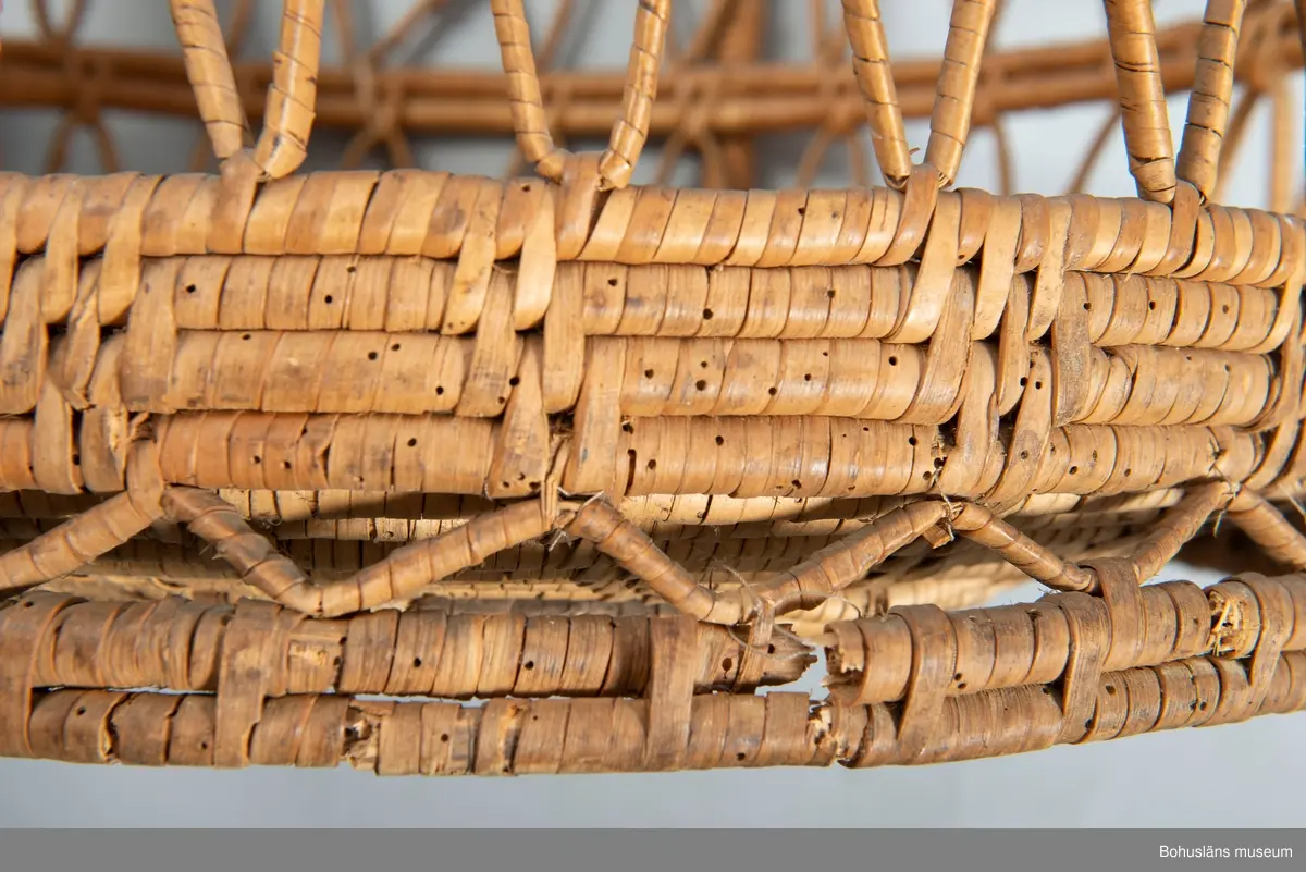 Korg med handtag. Betydande skador.

Ur handskrivna katalogen 1957-1958:
Brudkorg
Diam. 46-47,5 H. c:a 50. Flätad korg. Obetydligt skadad. Maskhål.

Inköpt av byggmästare Nordkvist för 5 kronor.