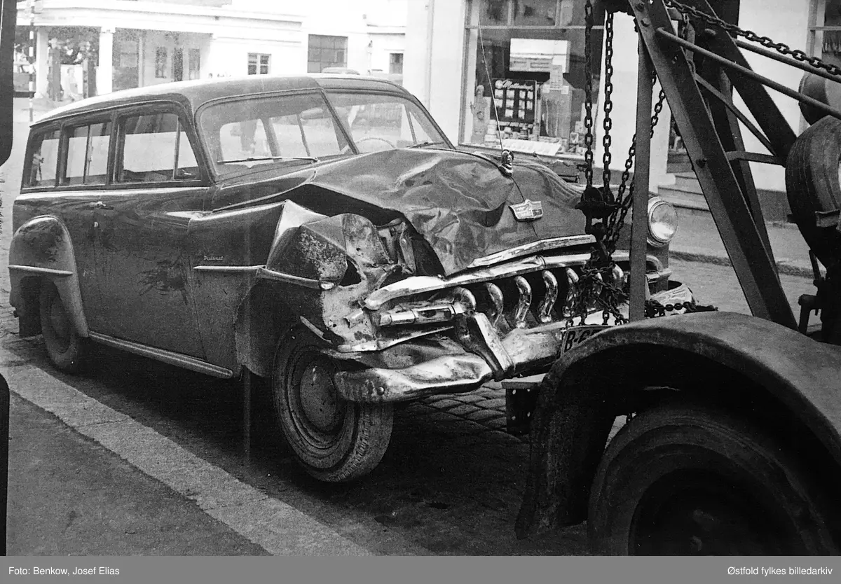 Kranbil med personbil med kollisjonsskader, i Moss. Det er en DeSoto Diplomat stasjonsvogn. Årsmodell 1953. Diplomat var en ren eksportmodell, egentlig en Plymouth med DeSotos mer eksklusive dekor.