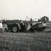 Traktor och självbindare på en åker vid Teleborgs slott i augusti 1949. T.v. greve Christer Bonde.