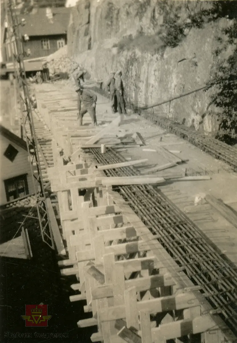 Østerklev bru i sentrum av Tvedestrand. Forskaling av brudekket, støping anno 1930. 
Plassbygget jf. bildene NVM 09-F-00833, NVM 09-F-00859 t.o.m. 00864. Tillegg til: NVM 09-F-01478 og 01479. 
Følg pilen til høyre for å se bildene fra byggingen. 
Bildene fra byggingen ved Østerklev bru er registrert enkeltvis. Se Relasjon lenger ned på siden. 

Østerklev bru, fv. 411 i Tvedestrand sentrum oppført 1930. Bjelkebru. Lengde 40,43 meter.
System: Betong. Spennvidde: 23,3 meter + 14,0 meter. Kjørebane: 4,6 meter. Bredde mellom rekkverk: 5,0 meter. Brudekke: Betong. Belastningsklasse: 2/30. Bygget 1930. 
Kilde: Statens vegvesen sitt bruregister "Brutus."