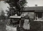 Kvinna vid vattenbrunn. Sommaren 1916. Ur album.
