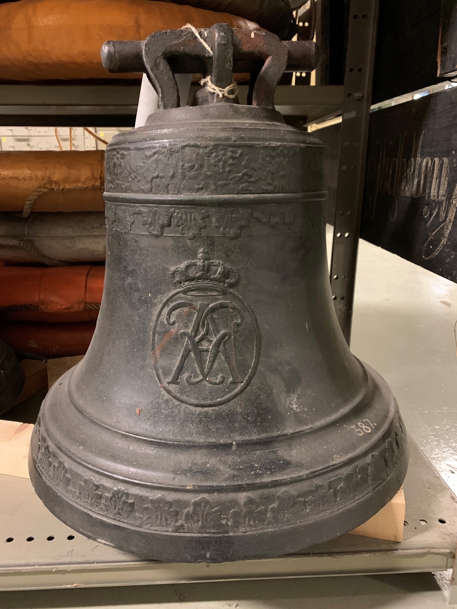 Skeppsklocka, av metall, gjuten år 1793, med följande inskription å ena sidan: "Gjuten i Carlskrona hos Marta C. Öfverström 1793". Å andra sidan ett namnchiffer "RGA" med kunglig krona över.