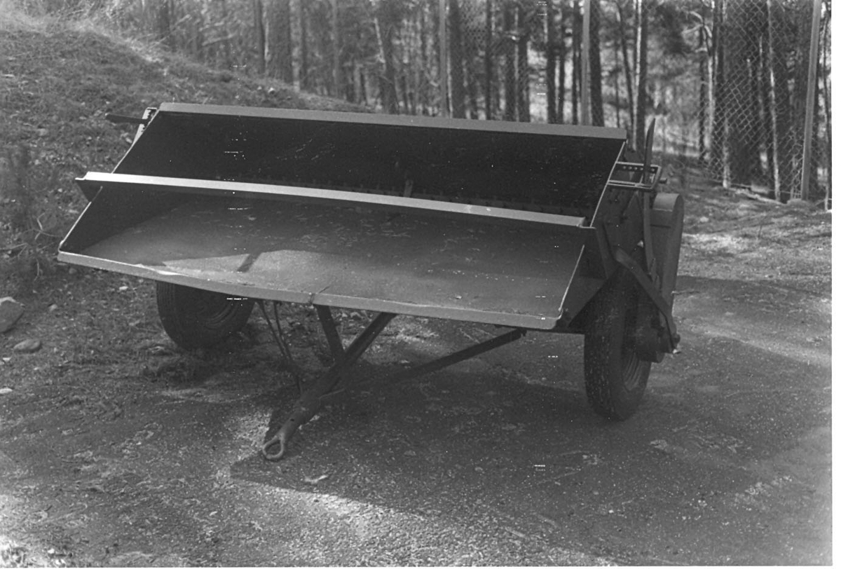 Grönmålad saltspridare, tidigare gulmålad. Två gummihjul.  Behållaren avsmalnande mot botten, öppning nertill, dragkrok.

Tillverkare: Skölins mek. verkstad
År: 1950-tal
Märkt på skylt: Vfn i H län, 
Maskin nr: Ss  111