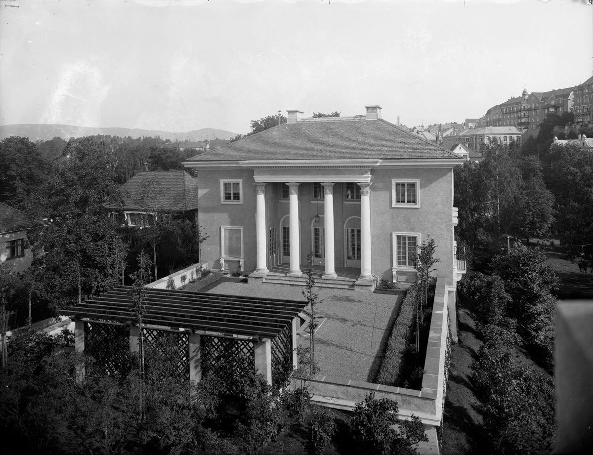 Villa i mur med Korintiske søyler
Singlet bakhage med prydbusker, vannspeil og pergola