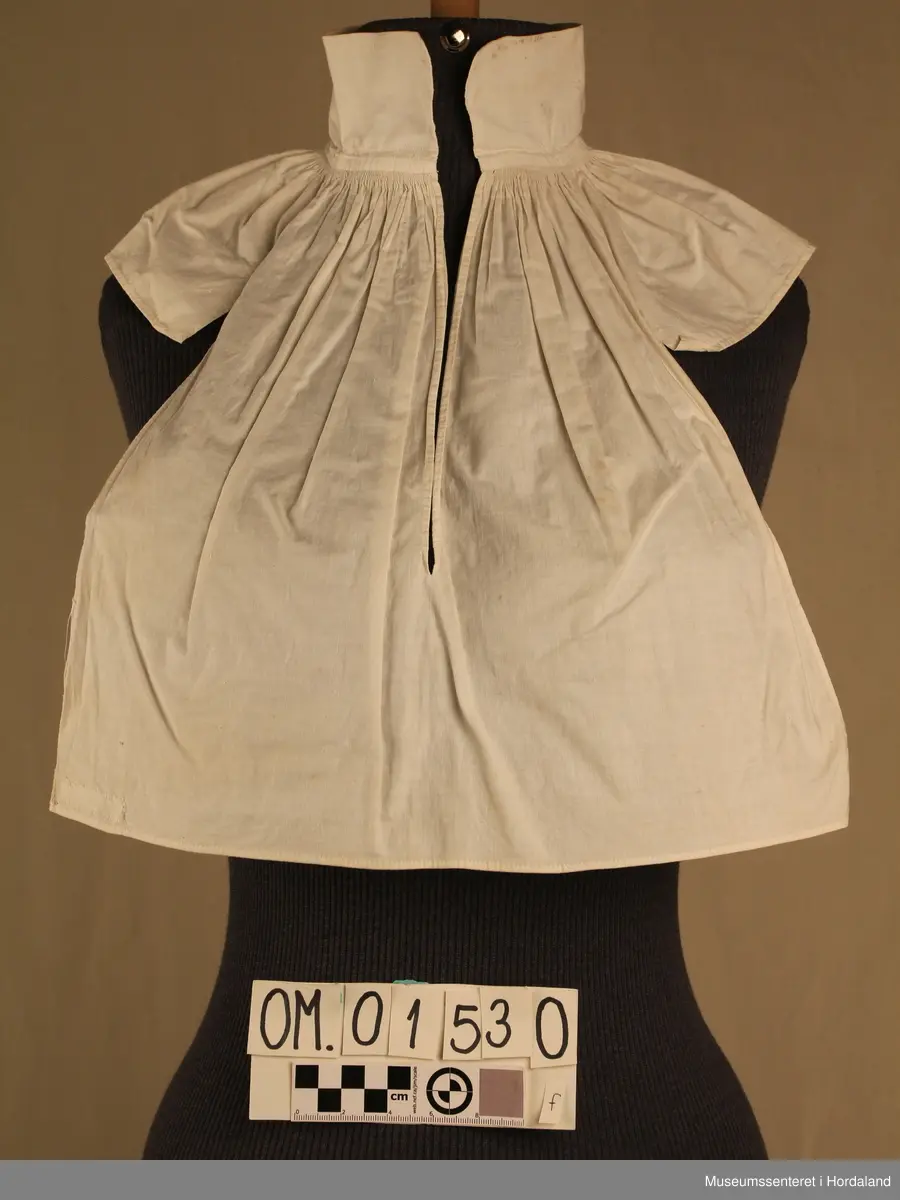 Tretten kvite halvskjorter i diverse utforming.