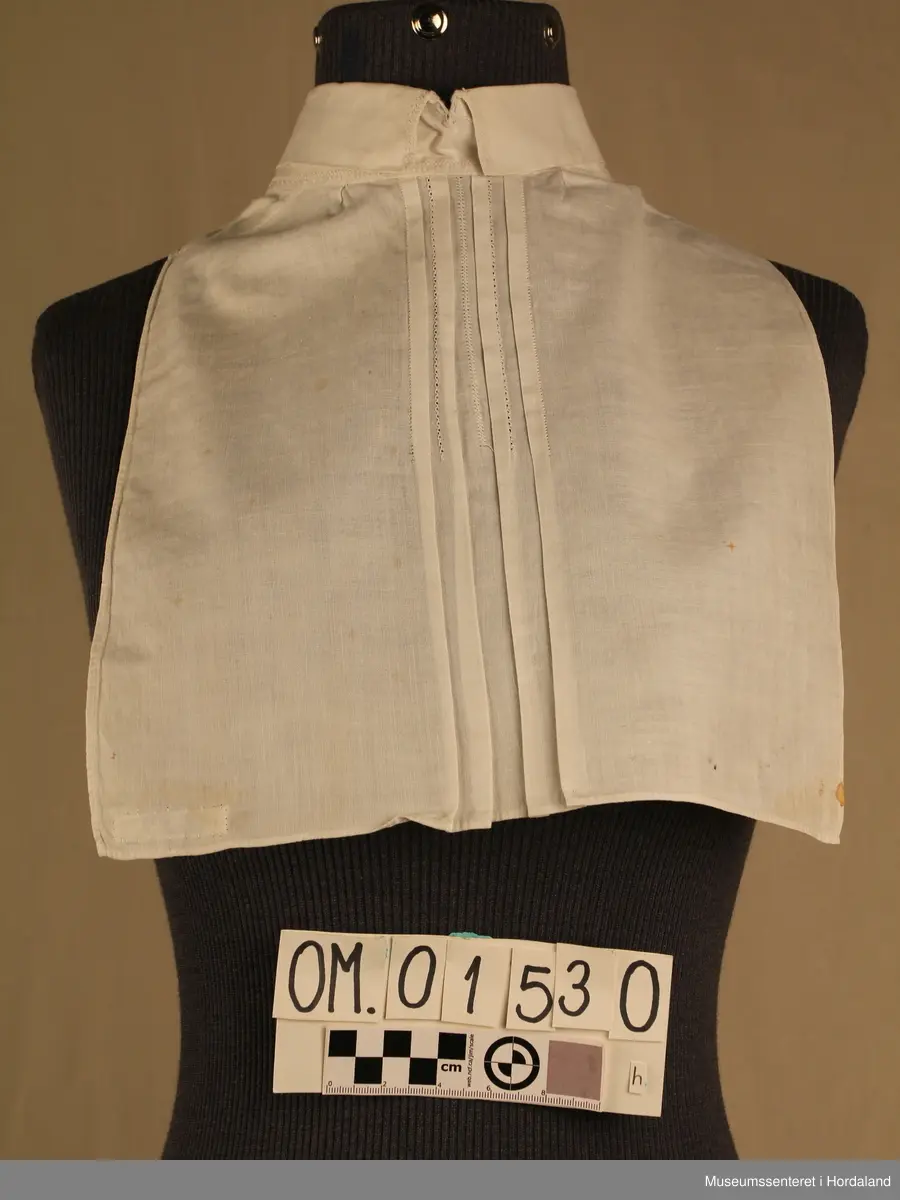 Tretten kvite halvskjorter i diverse utforming.