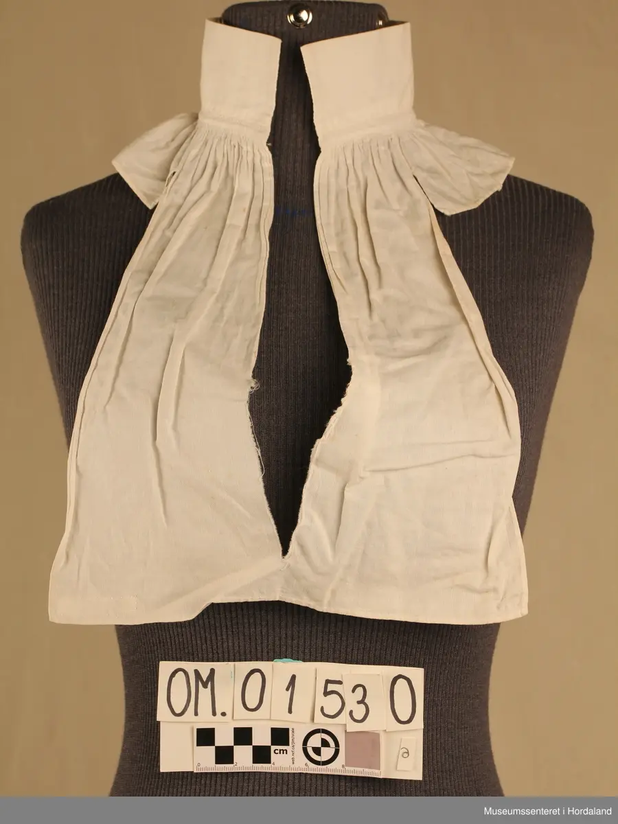 Tretten kvite halvskjorter i diverse utforming.