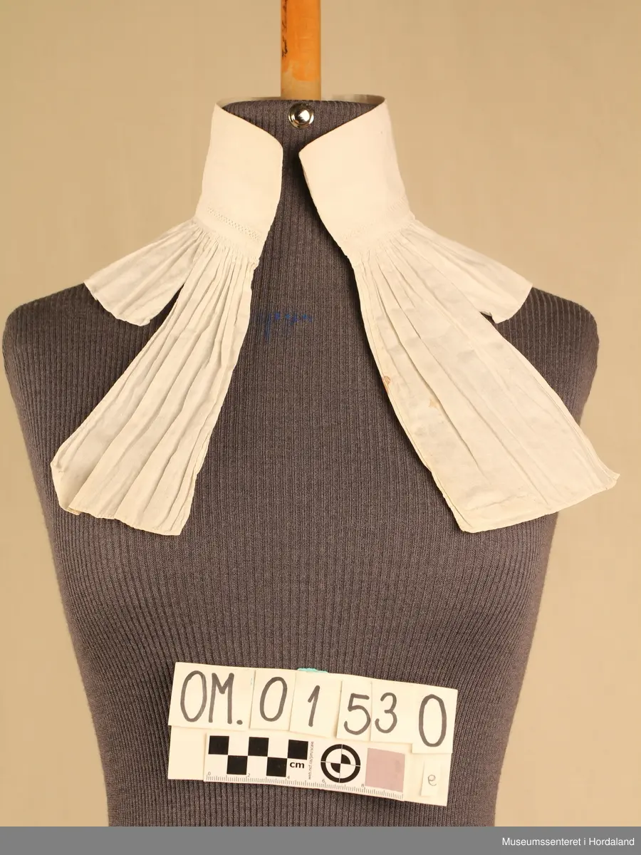 Tretten kvite halvskjorter i diverse utforming.