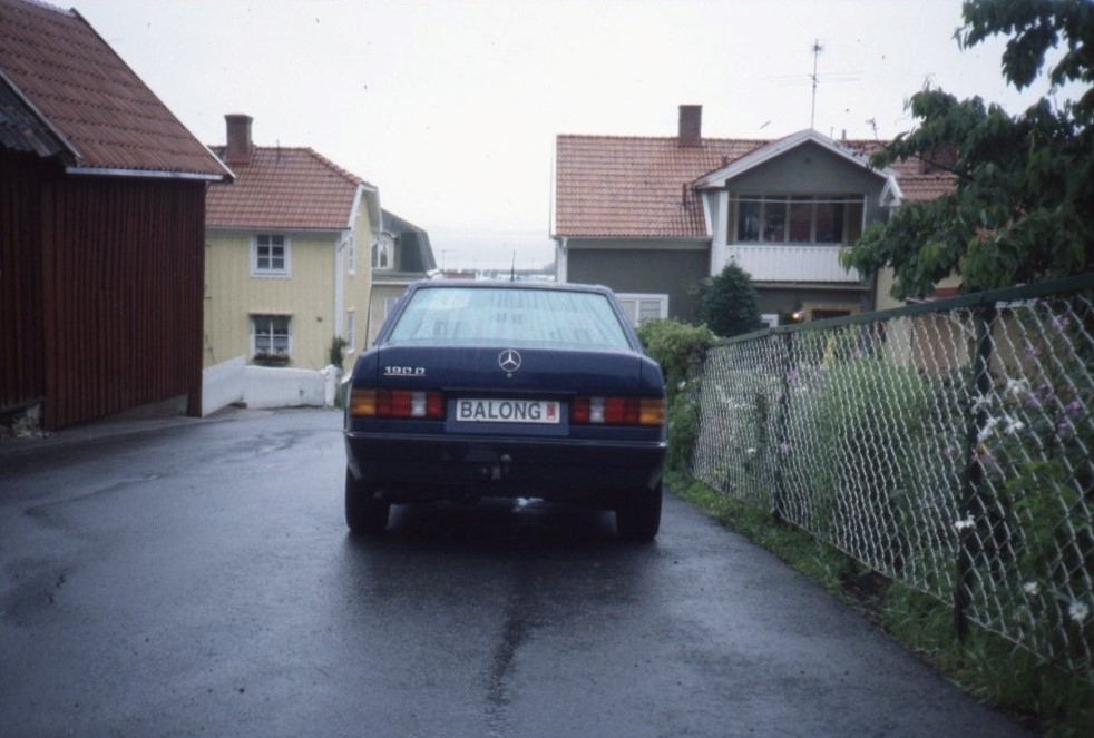 Hamnvägen från Bergsgatan västerut. På gatan står en blå Mercedes parkerad med registreringsplåt BALONG.
