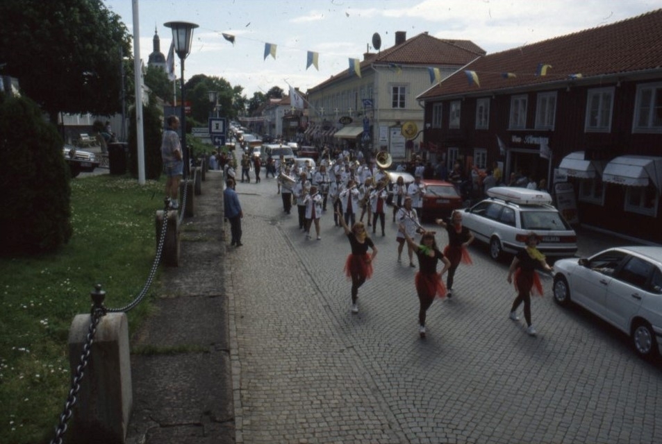 Vy över Brahegatan där en paraderande orkester rör sig mot norr.