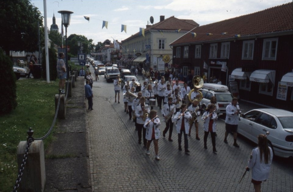 Vy över Brahegatan där en paraderande orkester rör sig mot norr.
