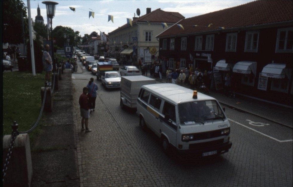 Vy över Brahegatan där en kortege av bilar med släp följer orkestern.