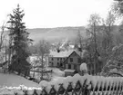 Erik Larssons, pensionat samt Johan Larssons lanthandel i snötäckt landskap. Snö.