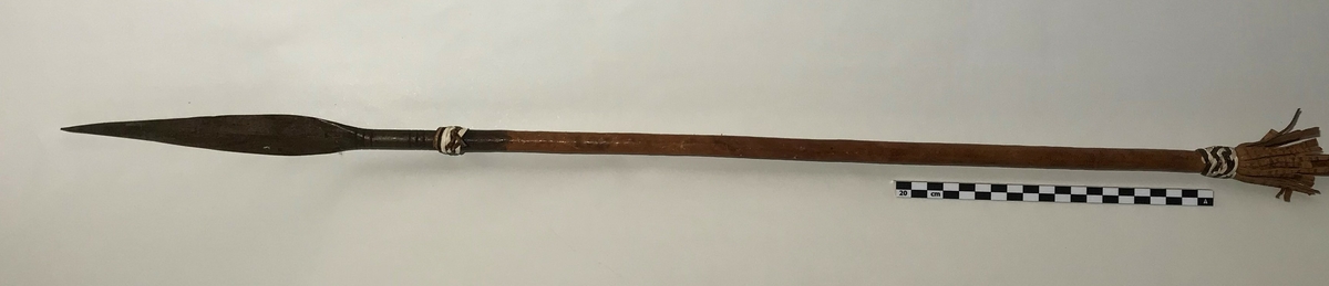 Spydet har spiss på begge endene. Spissen fremme er trekantet,  og den bakre enden har en avlang (firkantet) spiss. Spydet har også dekor av hvite lintråder som er surret pent fast og laget som dusk.