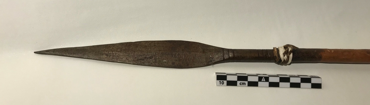 Spydet har spiss på begge endene. Spissen fremme er trekantet,  og den bakre enden har en avlang (firkantet) spiss. Spydet har også dekor av hvite lintråder som er surret pent fast og laget som dusk.