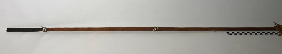 Spydet har spiss på begge endene. Spissen fremme er trekantet,  og den bakre enden har en avlang (firkantet) spiss. Spydet har også dekor av hvite lintråder som er surret pent fast og laget som dusk.