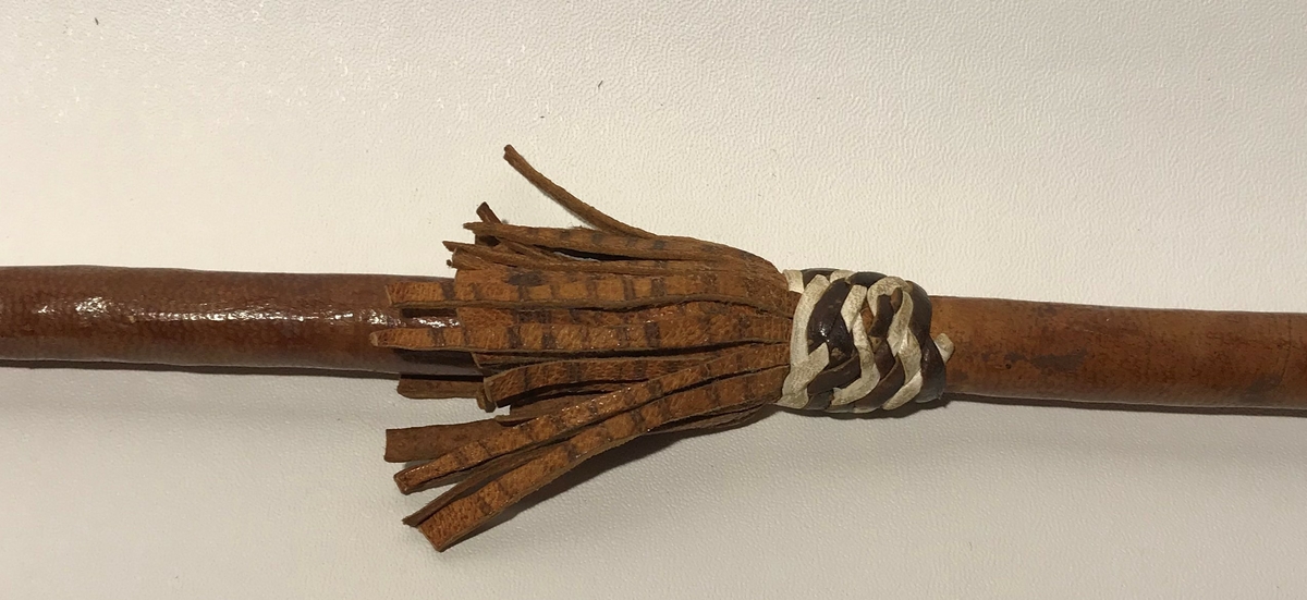 Spydet har spiss på begge endene. Spissen fremme er trekantet,  og den bakre enden har en avlang (firkantet) spiss. Spydet har også dekor av hvite lintråder som er surret pent fast og laget som dusk.