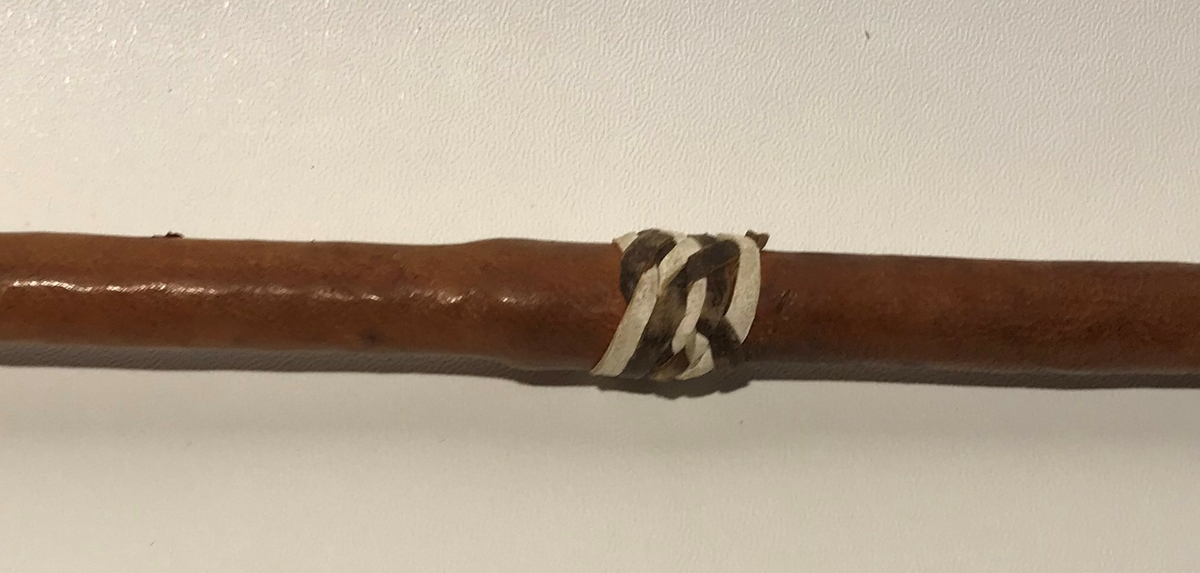 Spydet har spiss på begge endene. Spissen fremme er trekantet,  og den bakre enden har en avlang (firkantet) spiss. Spydet har også dekor av hvite lintråder som er surret pent fast og laget som dusk.