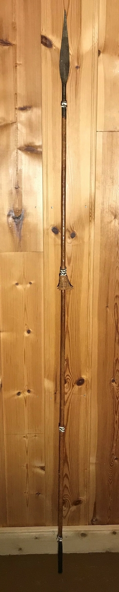 Spydet har spiss på begge endene. Spissen fremme er trekantet,  og den bakre enden har en avlang (firkantet) spiss. Spydet har også dekor av hvite lintråder som er surret pent fast og laget som dusk.