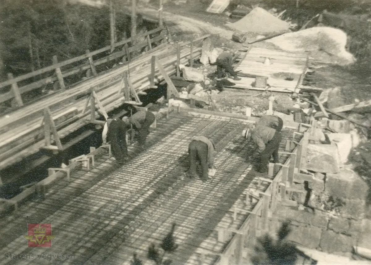 Østerklev bru i sentrum av Tvedestrand. Forskaling av brudekket, støping anno 1930. 
Plassbygget jf. bildene NVM 09-F-00833, NVM 09-F-00859 t.o.m. 00864. Tillegg til: NVM 09-F-01478 og 01479. 
Følg pilen til høyre for å se bildene fra byggingen. 
Bildene fra byggingen ved Østerklev bru er registrert enkeltvis. Se Relasjon lenger ned på siden. 

Østerklev bru, fv. 411 i Tvedestrand sentrum oppført 1930. Bjelkebru. Lengde 40,43 meter.
System: Betong. Spennvidde: 23,3 meter + 14,0 meter. Kjørebane: 4,6 meter. Bredde mellom rekkverk: 5,0 meter. Brudekke: Betong. Belastningsklasse: 2/30. Bygget 1930. 
Kilde: Statens vegvesen sitt bruregister "Brutus."