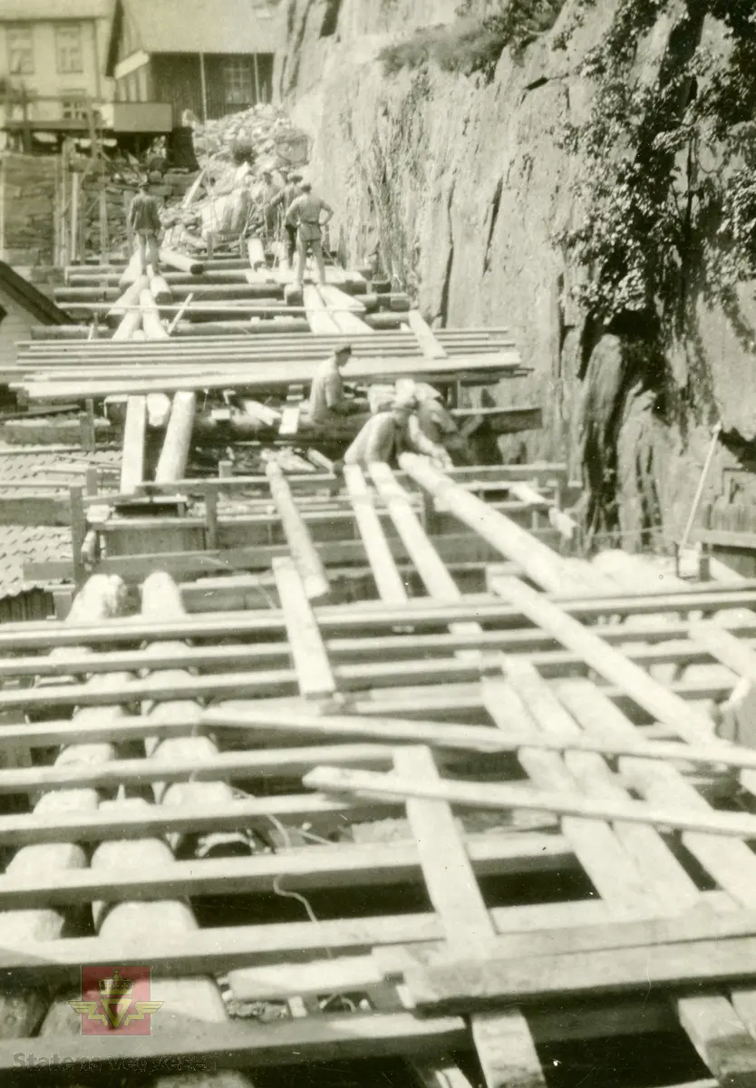 Østerklev bru i sentrum av Tvedestrand. Forskaling av brudekket, støping anno 1930. 
Plassbygget jf. bildene NVM 09-F-00833, NVM 09-F-00859 t.o.m. 00864. Tillegg til: NVM 09-F-01478 og 01479. 
Følg pilen til høyre for å se bildene fra byggingen. 
Bildene fra byggingen ved Østerklev bru er registrert enkeltvis. Se Relasjon lenger ned på siden. 

Østerklev bru, fv. 411 i Tvedestrand sentrum oppført 1930. Bjelkebru. Lengde 40,43 meter.
System: Betong. Spennvidde: 23,3 meter + 14,0 meter. Kjørebane: 4,6 meter. Bredde mellom rekkverk: 5,0 meter. Brudekke: Betong. Belastningsklasse: 2/30. Bygget 1930. 
Kilde: Statens vegvesen sitt bruregister "Brutus."