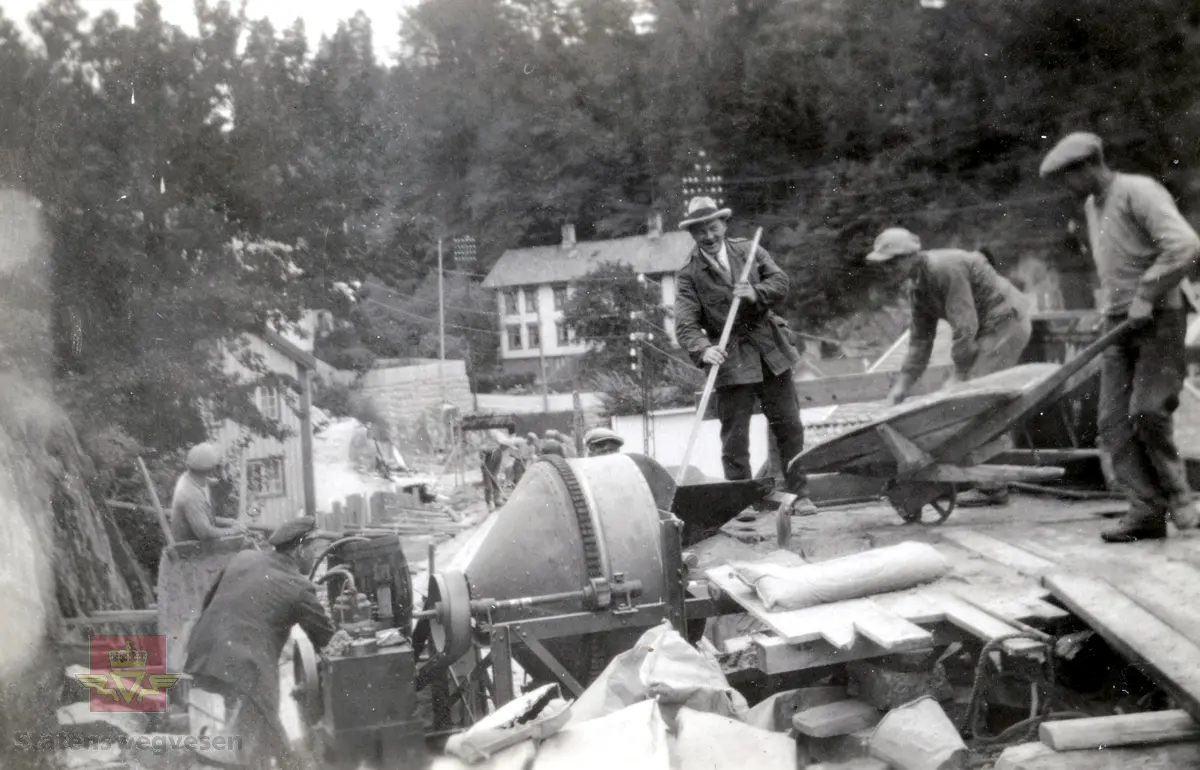 Østerklev bru i sentrum av Tvedestrand. Forskaling av brudekket, støping anno 1930. 
Plassbygget jf. bildene NVM 09-F-00833, NVM 09-F-00859 t.o.m. 00864. Tillegg til: NVM 09-F-01478 og 01479. 
Følg pilen til høyre for å se bildene fra byggingen. 
Bildene fra byggingen ved Østerklev bru er registrert enkeltvis. Se Relasjon lenger ned på siden. 

Østerklev bru, fv. 411 i Tvedestrand sentrum oppført 1930. Bjelkebru. Lengde 40,43 meter.
System: Betong. Spennvidde: 23,3 meter + 14,0 meter. Kjørebane: 4,6 meter. Bredde mellom rekkverk: 5,0 meter. Brudekke: Betong. Belastningsklasse: 2/30. Bygget 1930. 
Kilde: Statens vegvesen sitt bruregister "Brutus."