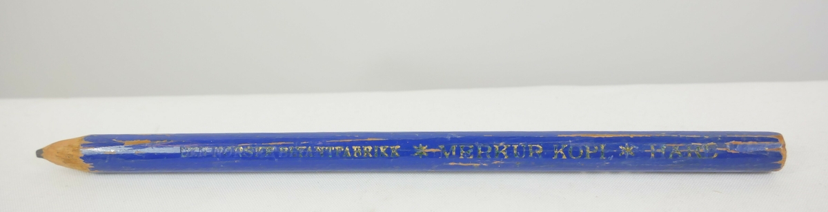 Rund gul blyant som har blitt spisset i den ene enden. Et metallbeslag nedenfor blyantspissen. 

Rund blå blyant som er spisset i den ene enden

Rund svart fyllepenn med lokk