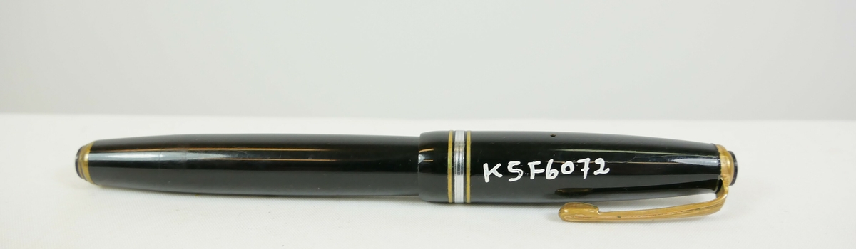 Rund gul blyant som har blitt spisset i den ene enden. Et metallbeslag nedenfor blyantspissen. 

Rund blå blyant som er spisset i den ene enden

Rund svart fyllepenn med lokk