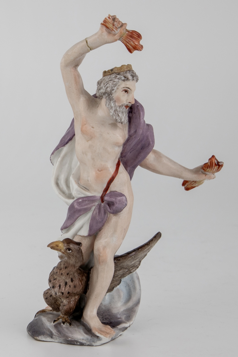 Figur av skjegget mann med ørn og tordenkiler i hendene, som skal forestille Jupiter/Zevs. Hvitglasert porselen med polykrom overglasurmaling. Han er iført et hvitt og lilla draperi, mens på hodet har han en tagget krone. Armene er hevet og han er fremstilt i det pregnante øyeblikk før han skal kaste tordenkilene.